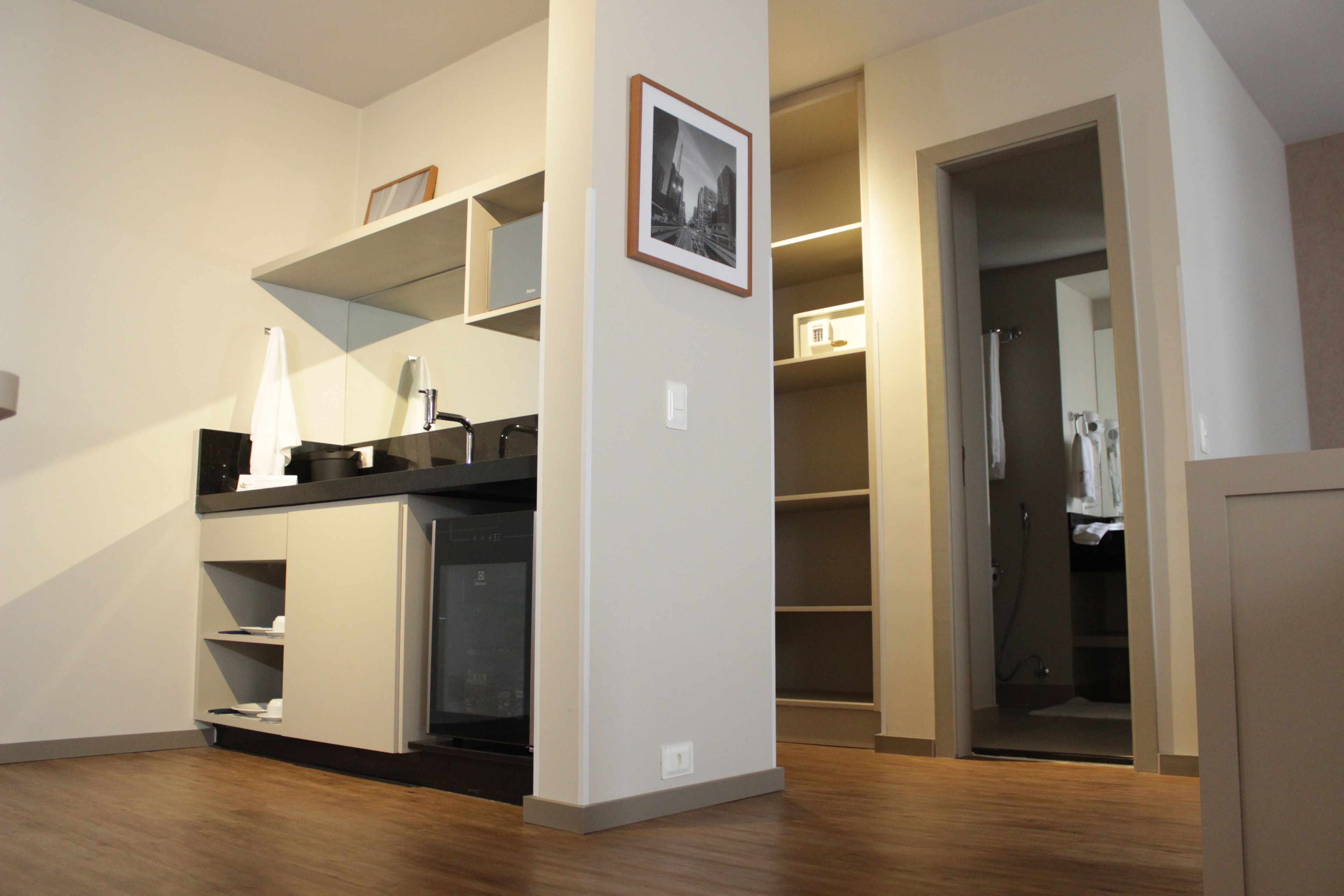 Una cocina moderna con electrodomésticos integrados, piso de madera y vistas a un vestidor.