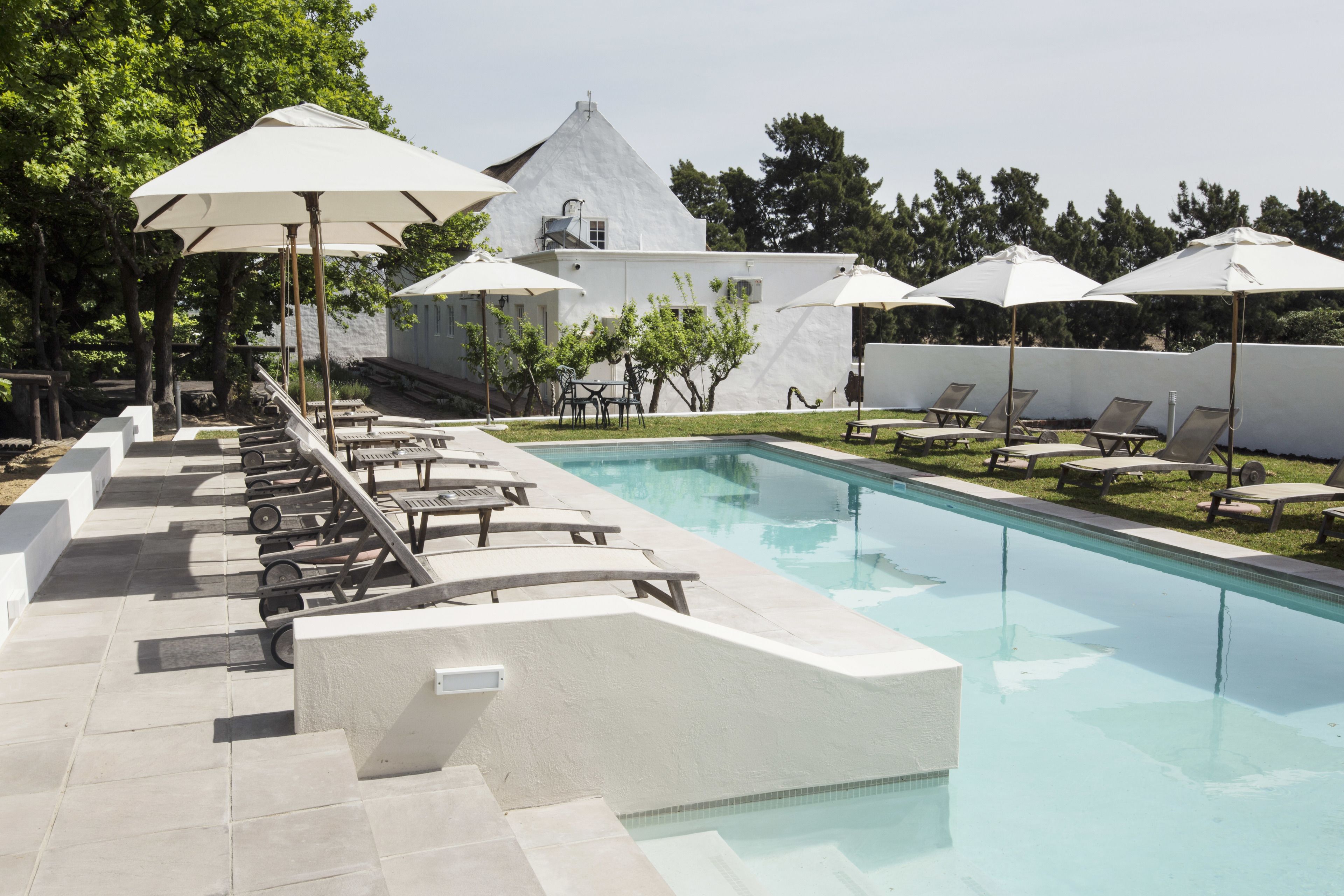 حمّام سباحة خارجي، مظلات على حمّام السباحة، مقاعد للتشمس