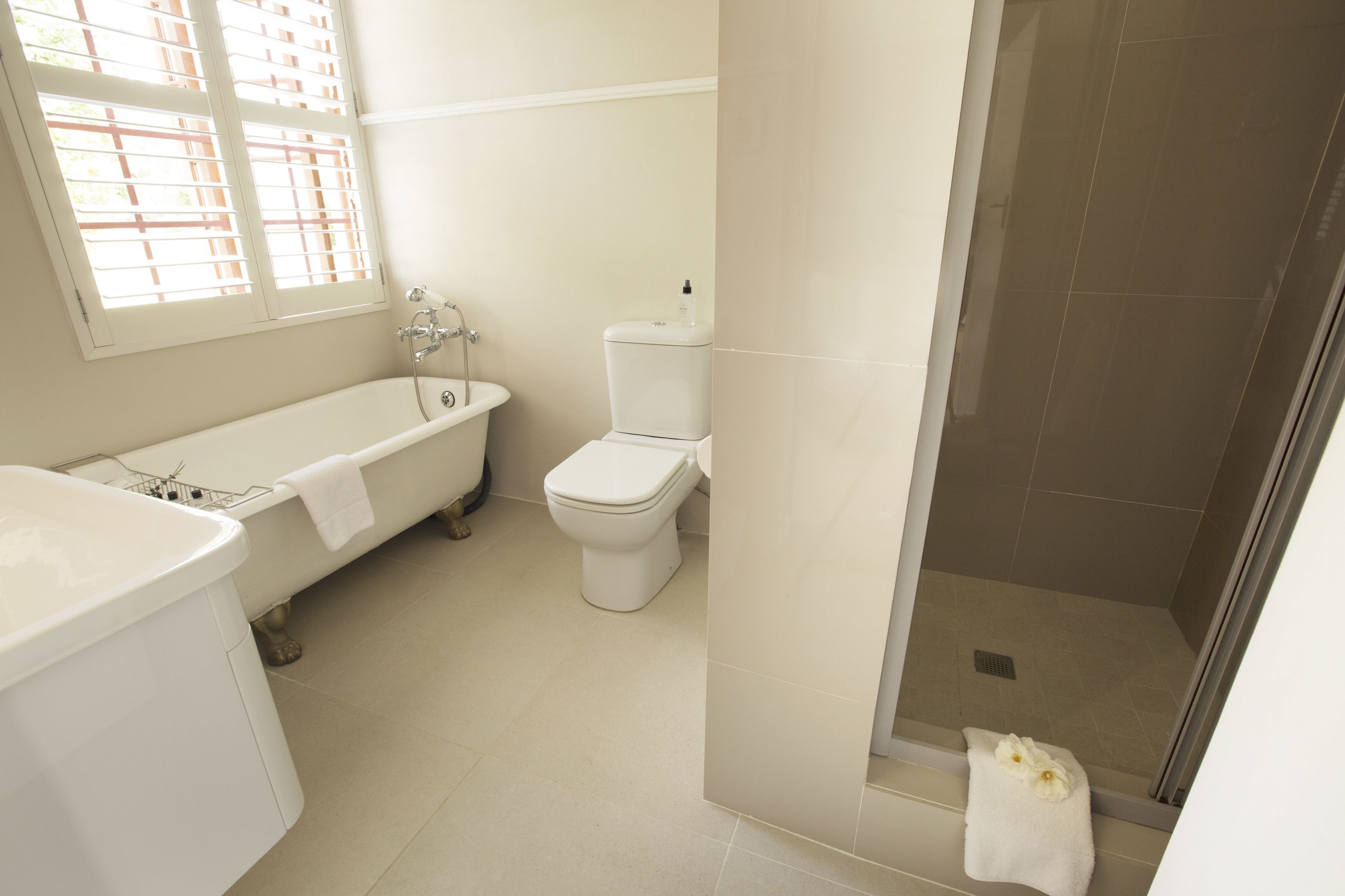 A bathroom with a bathtub, toilet, and shower area.