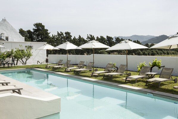 Piscine extérieure, parasols de plage, chaises longues
