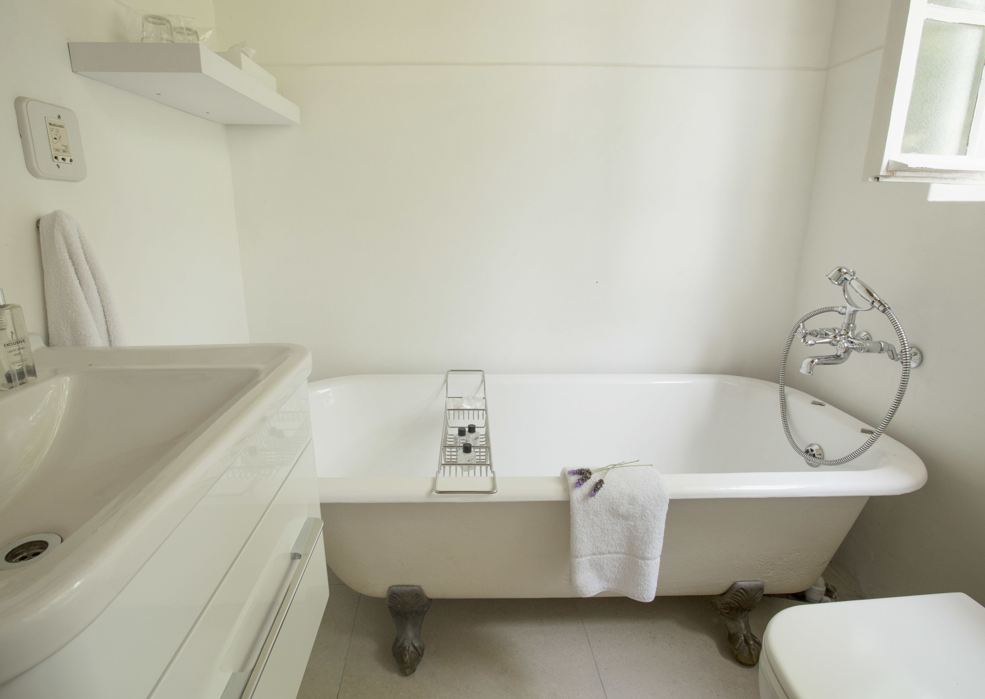 A bathroom with a white bathtub, a white sink, and a shower.