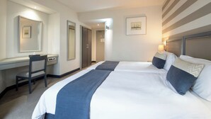 A hotel room with a large bed, a desk, a chair, and a mirror. - The Portswood Hotel (Cape Town)
