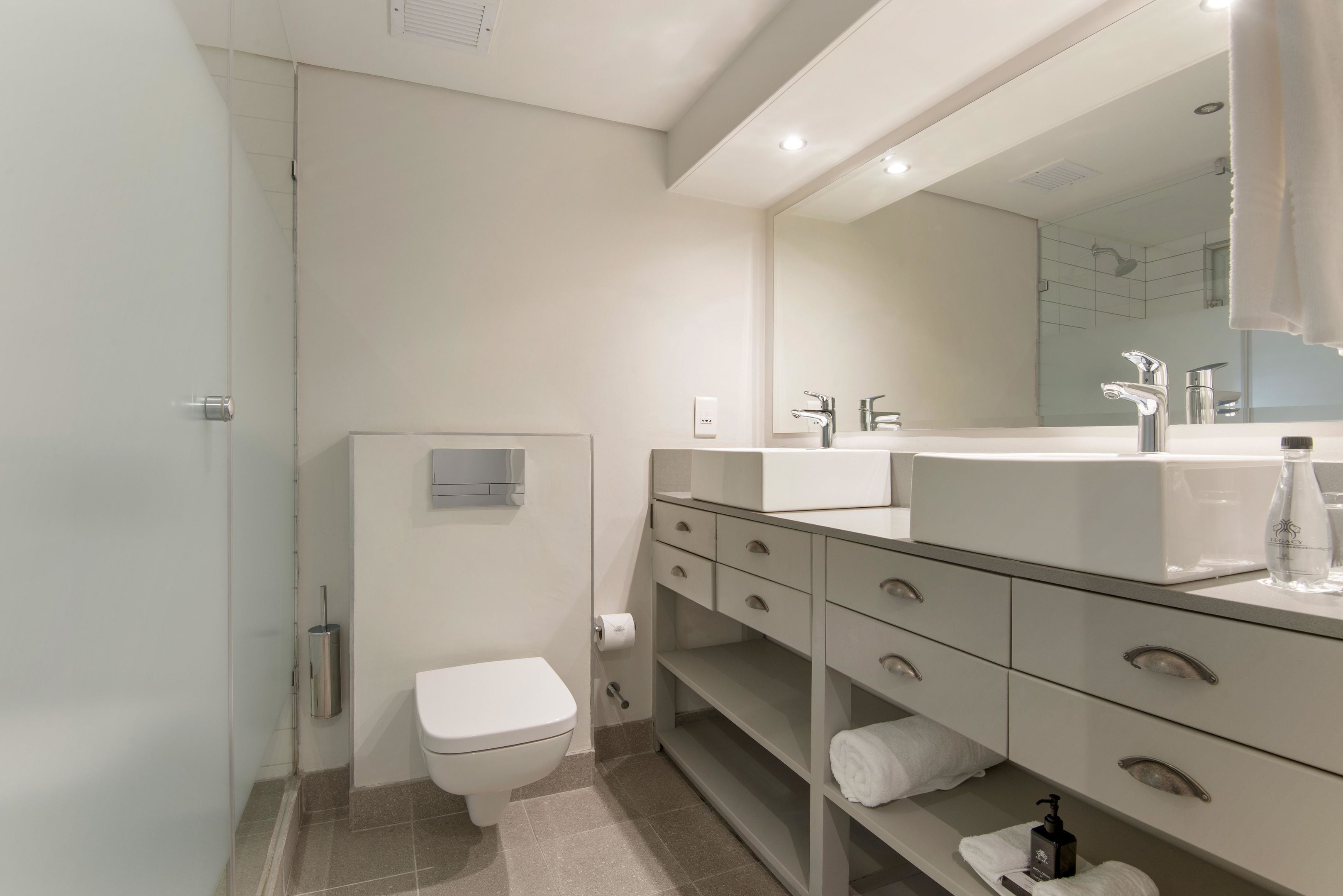 A modern bathroom with a toilet, sink, and vanity.