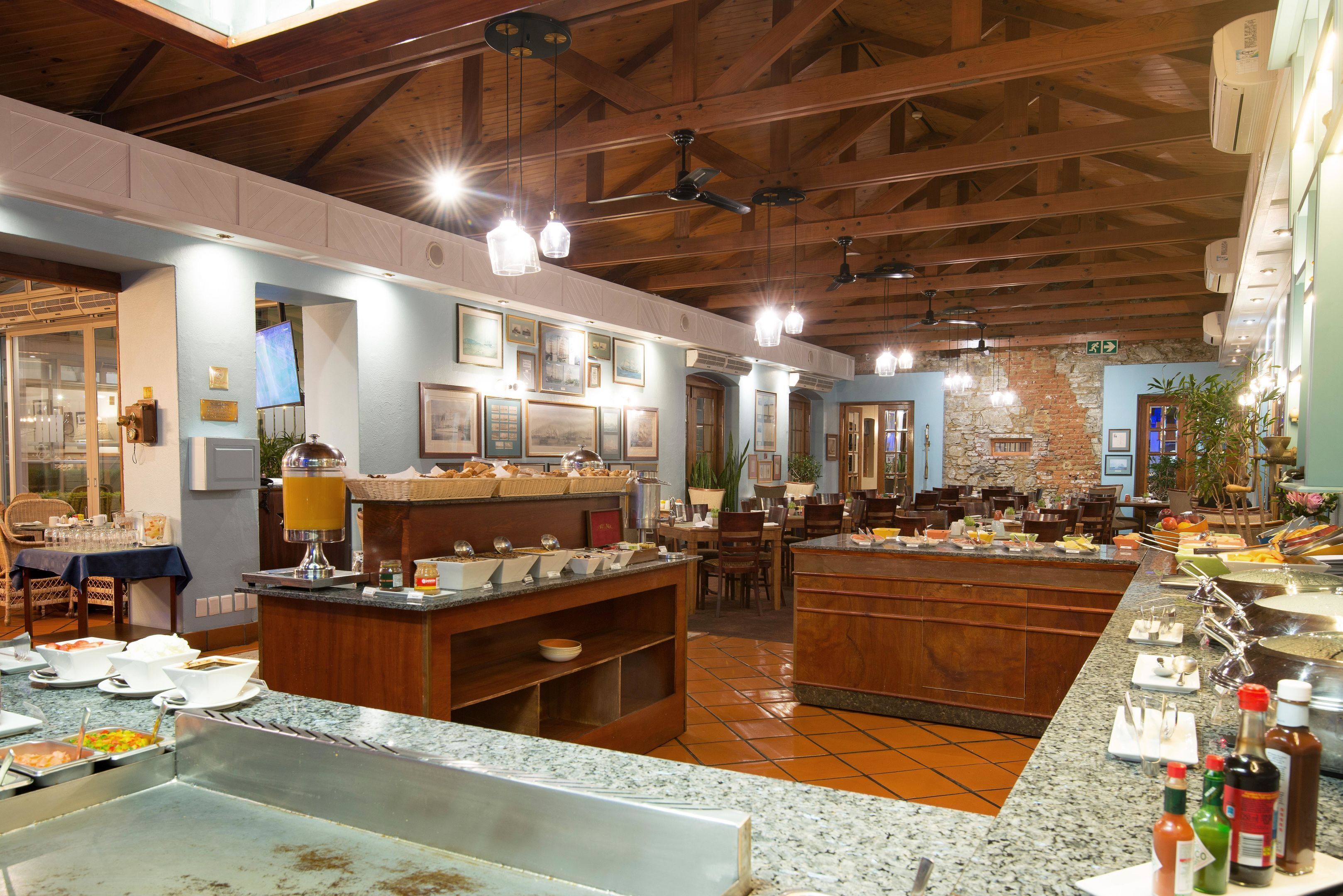 Un ristorante con un buffet, travi in legno a soffitto e una parete in pietra.