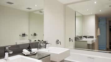 Un baño moderno con dos lavamanos, un espejo grande y una ducha a ras de suelo.
