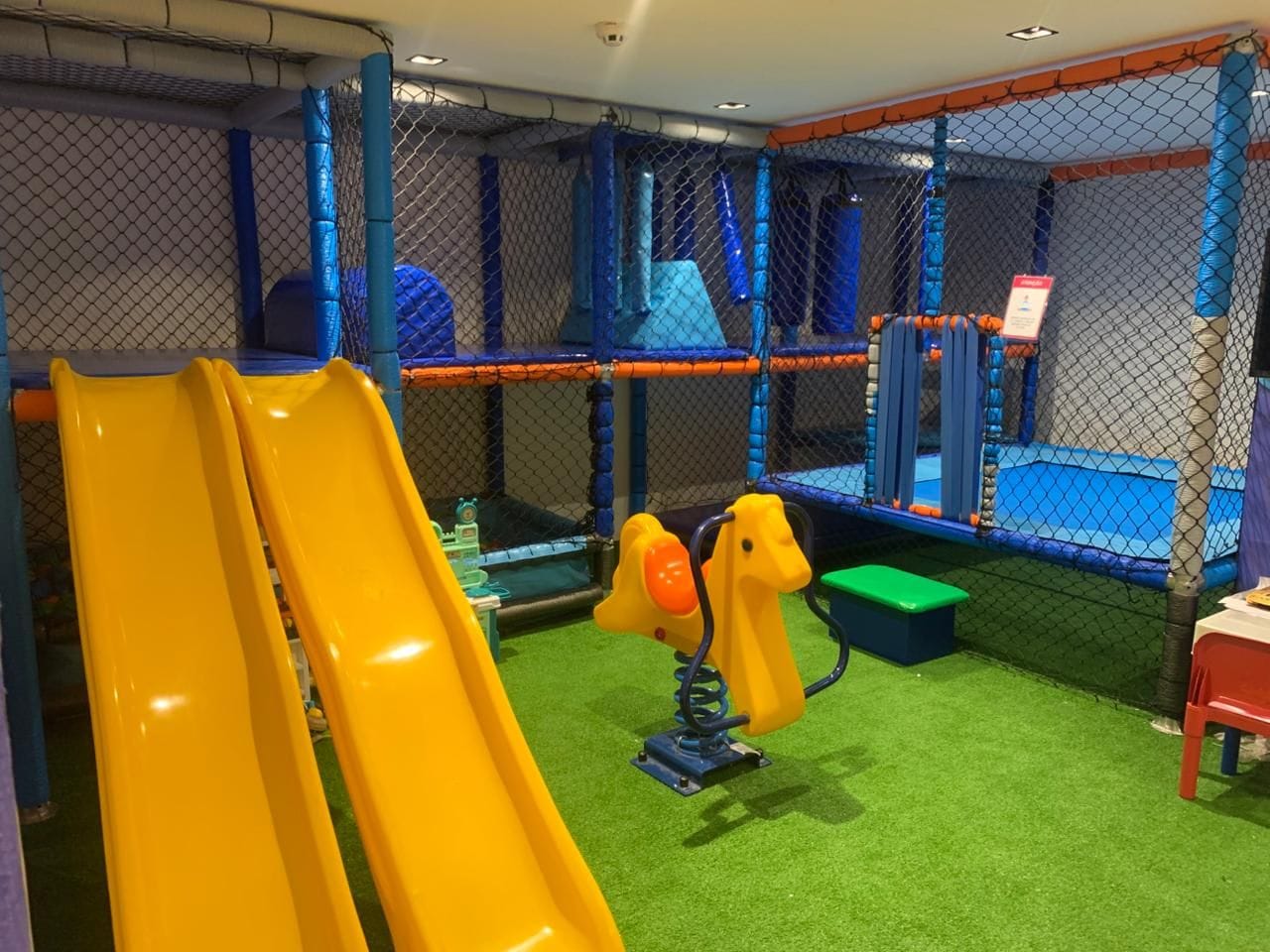 A play area with a slide, climbing structures, and a bench.
