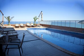 Una piscina al aire libre, sombrillas