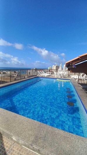 Alberca al aire libre y camastros