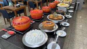 A buffet setup with various food items and serving utensils.