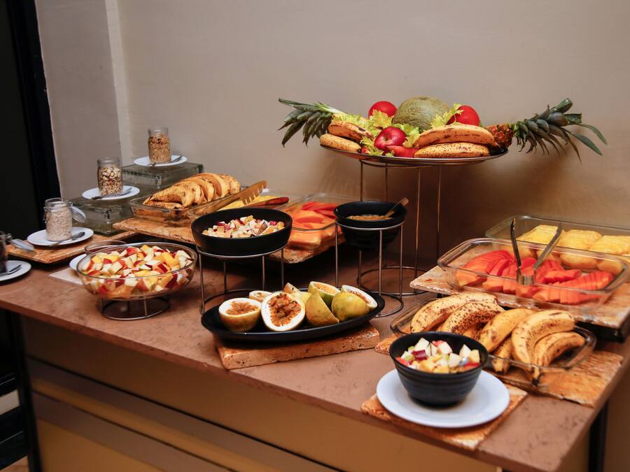 Un bufé con frutas, verduras y pasteles varios.