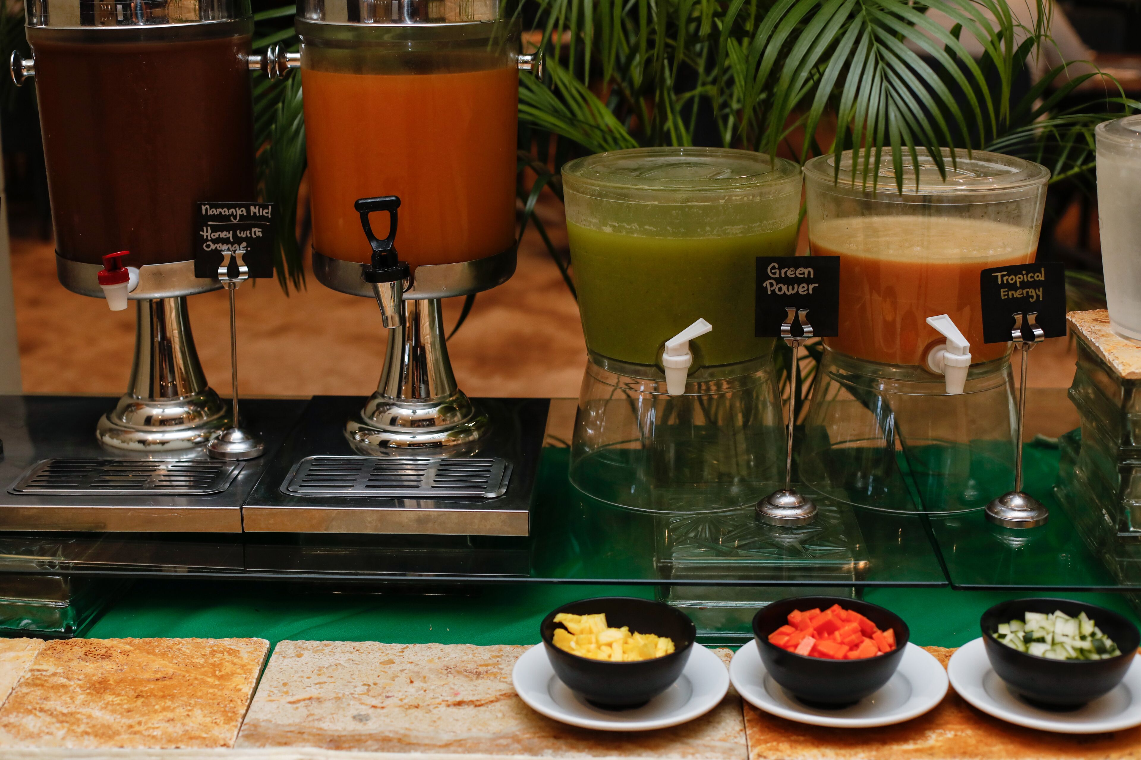 A juice bar with various drink options and fresh fruit bowls.