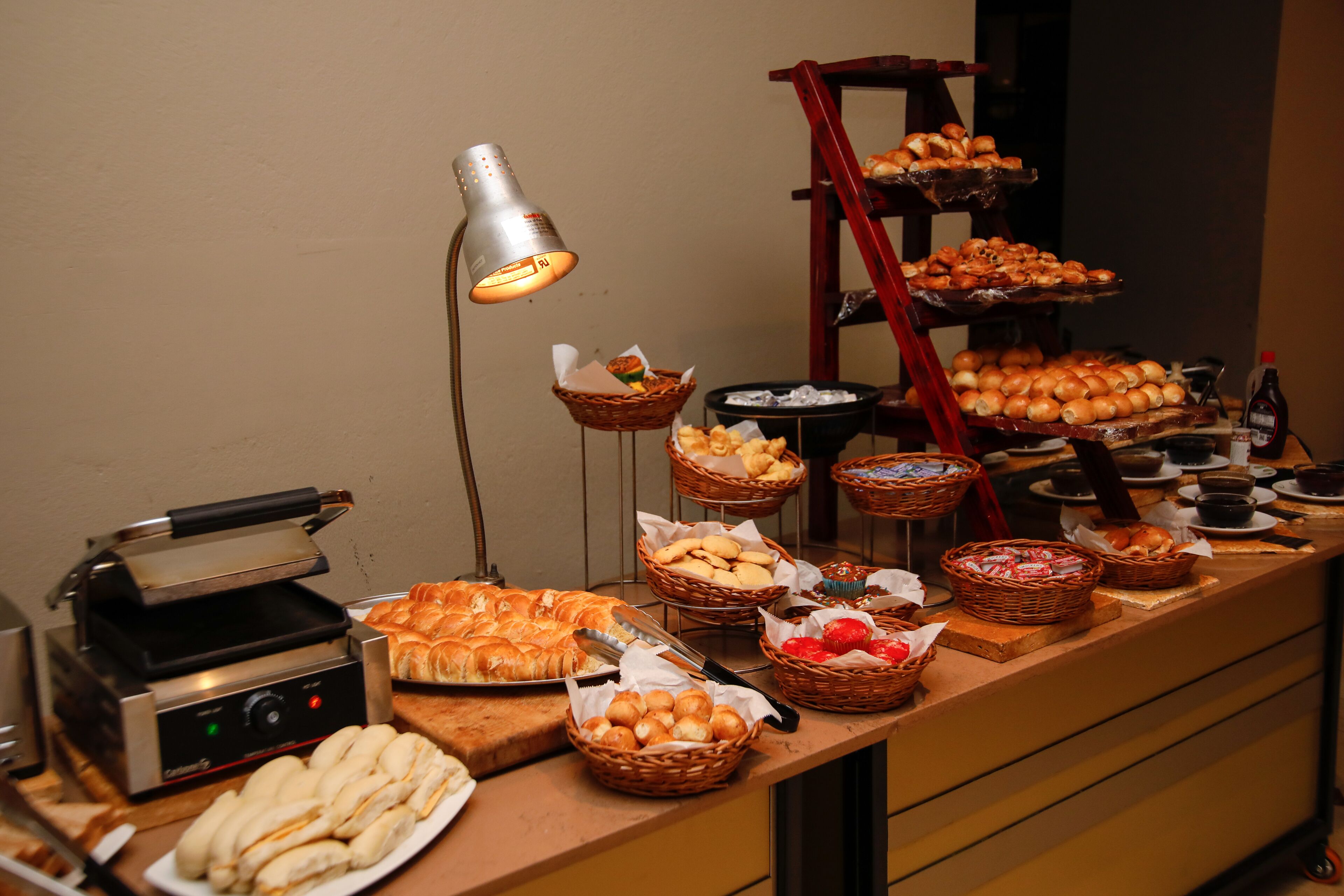 A buffet with various baked goods, a toaster, and baskets of food.