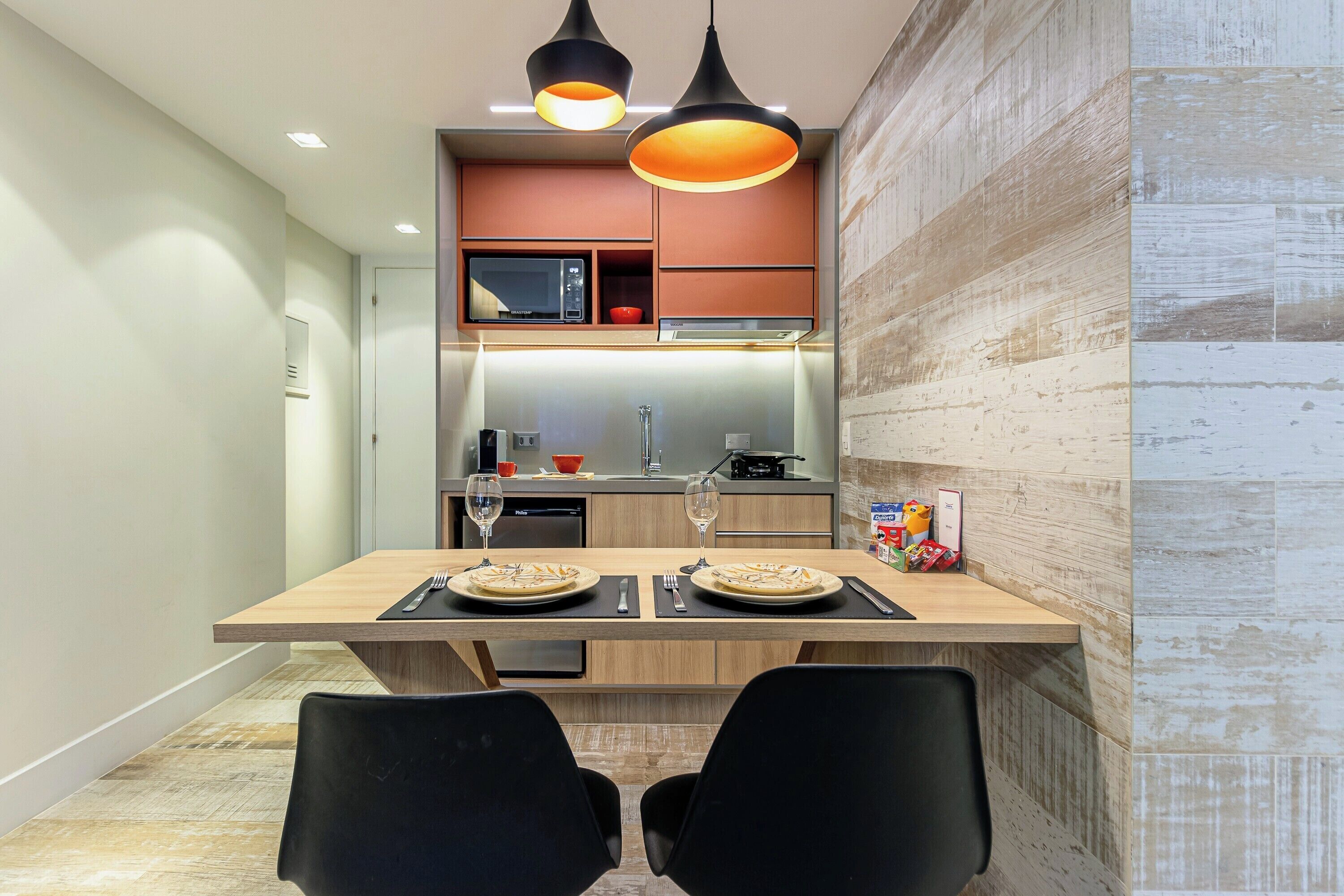A modern kitchen with a central island, overhead lighting, and a microwave above the counter.