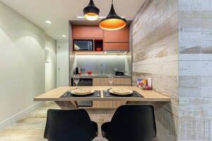 A modern kitchen with a central island, overhead lighting, and a microwave above the counter.