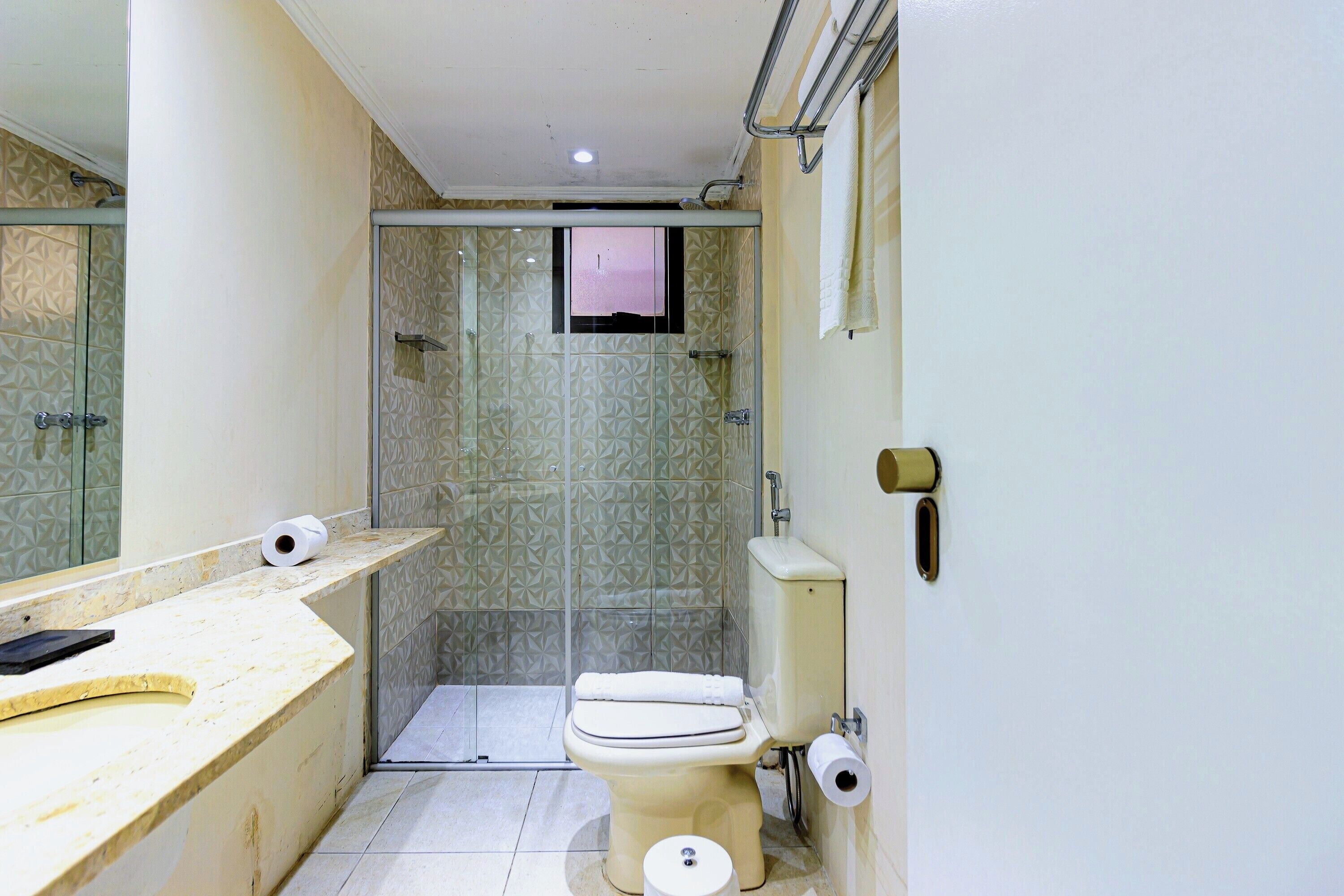 A small bathroom with a toilet, a sink, and a shower stall.