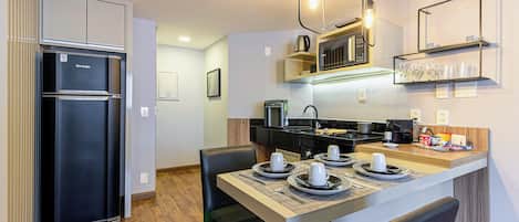 A compact kitchen with a refrigerator, microwave, and coffee maker.