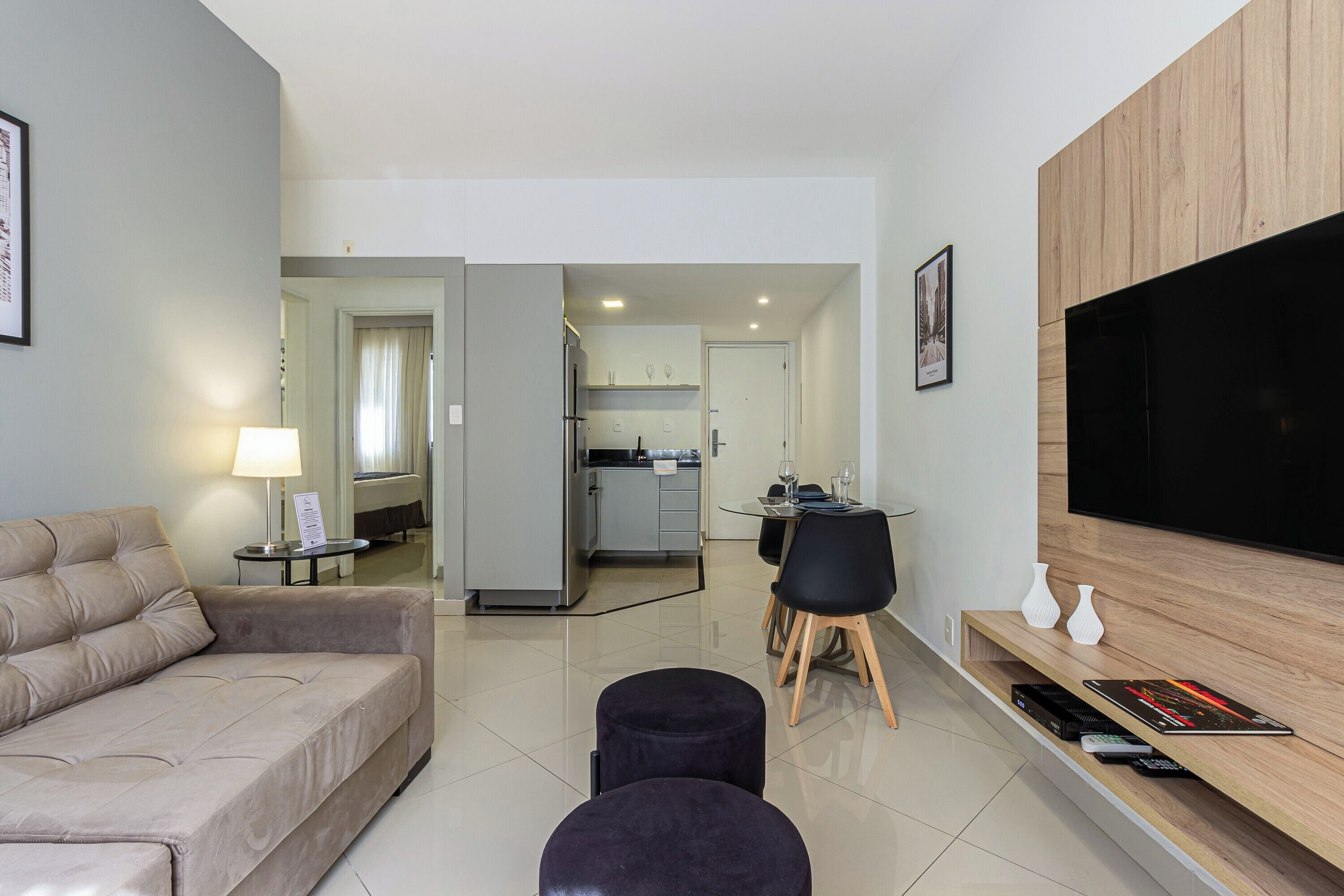 Una sala de estar moderna con un sofá, un televisor y un comedor con mesa y sillas.
