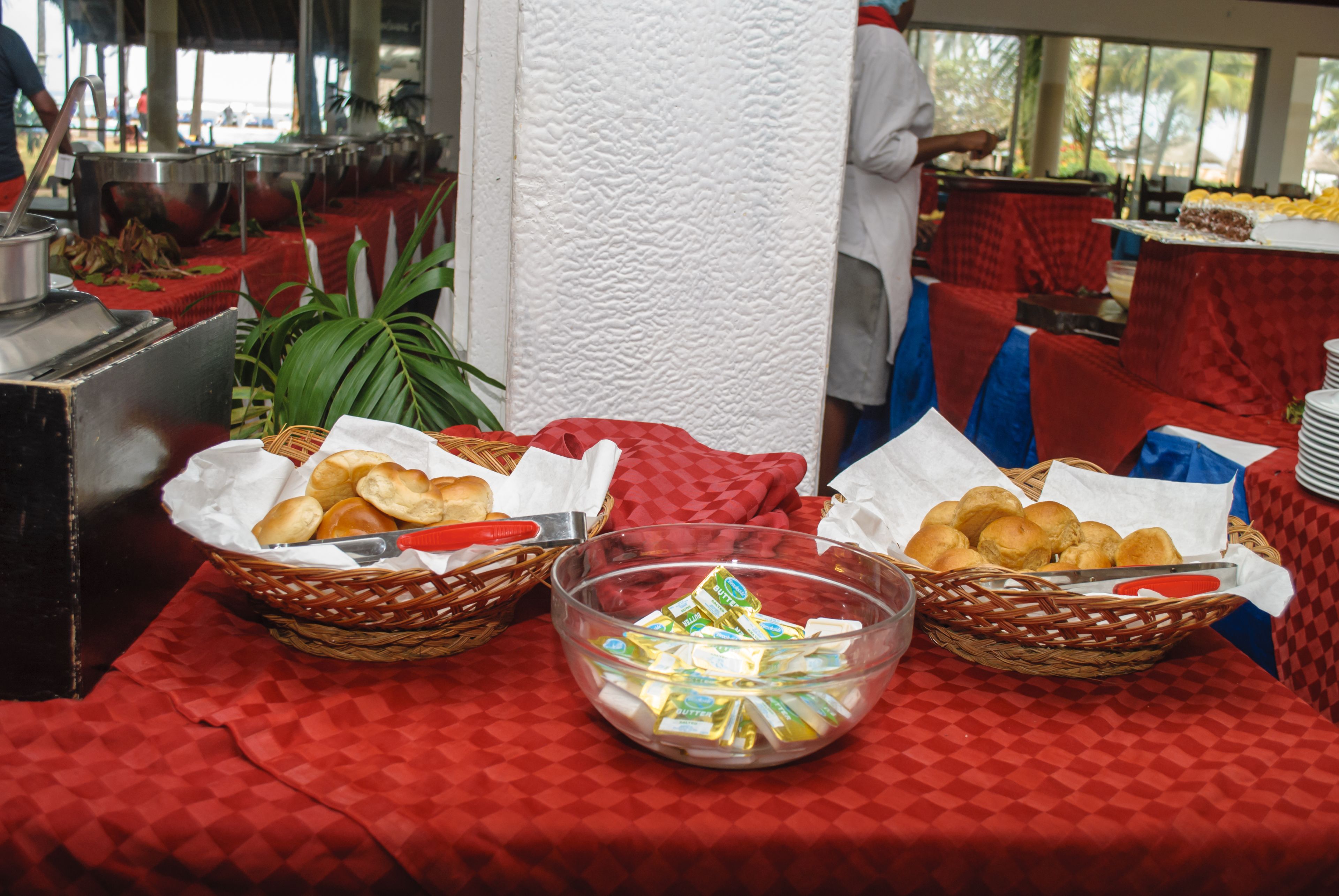 Un buffet avec des paniers remplis de nourriture et un récipient contenant des condiments.