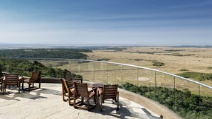A terrace with outdoor seating and a panoramic view of a landscape.