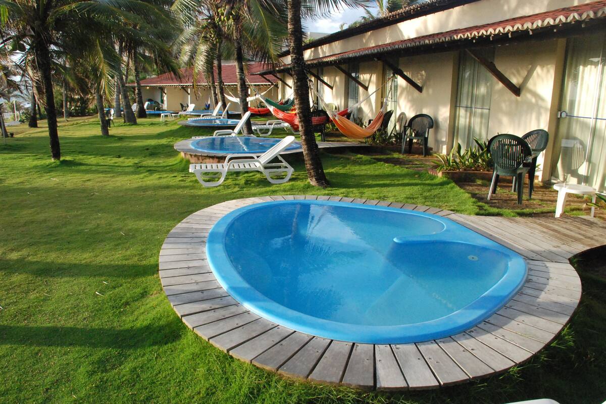 Un área de piscina con sillas de descanso y una hamaca.