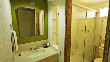 Un baño con lavabo, espejo y cabina de ducha de vidrio.