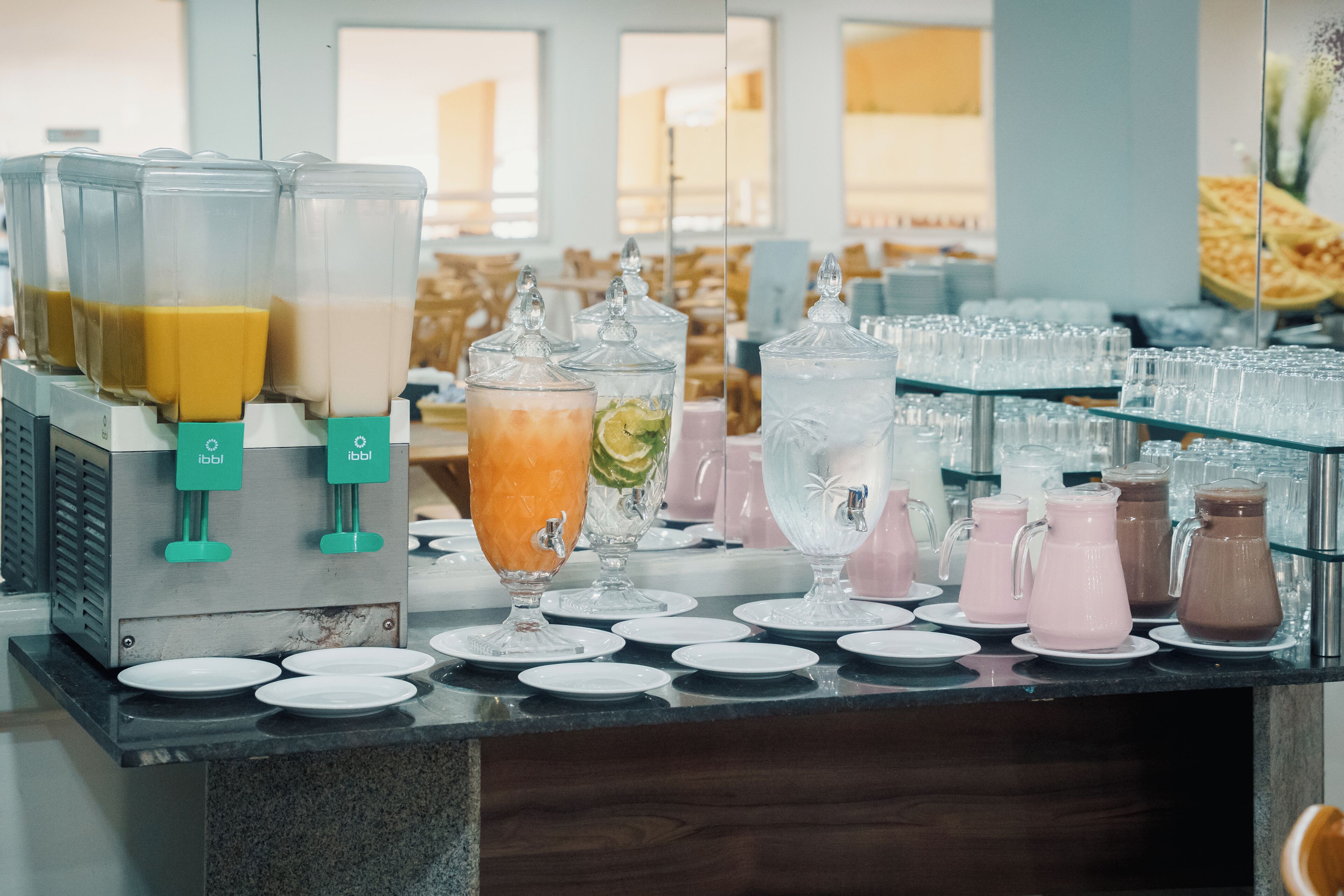 A beverage station with multiple dispensers and a variety of drink containers.