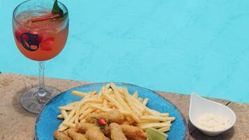 Prato de comida e bebida à beira da piscina.