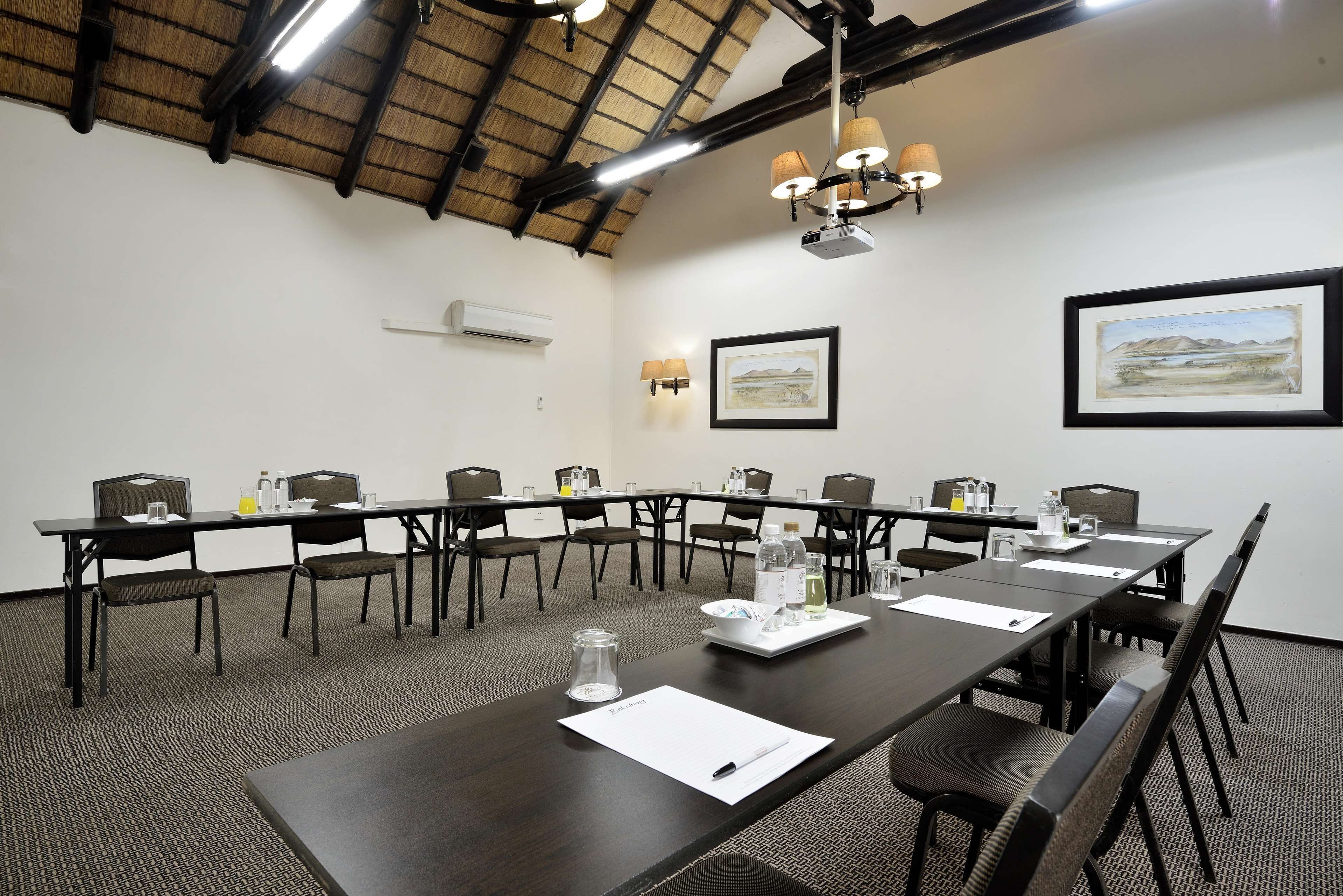 A conference room with a long table, chairs, and a ceiling with exposed beams.