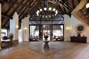A spacious lobby with a high ceiling, a central round table, and seating areas. - Kwa Maritane Bush Lodge (Pilanesberg National Park)