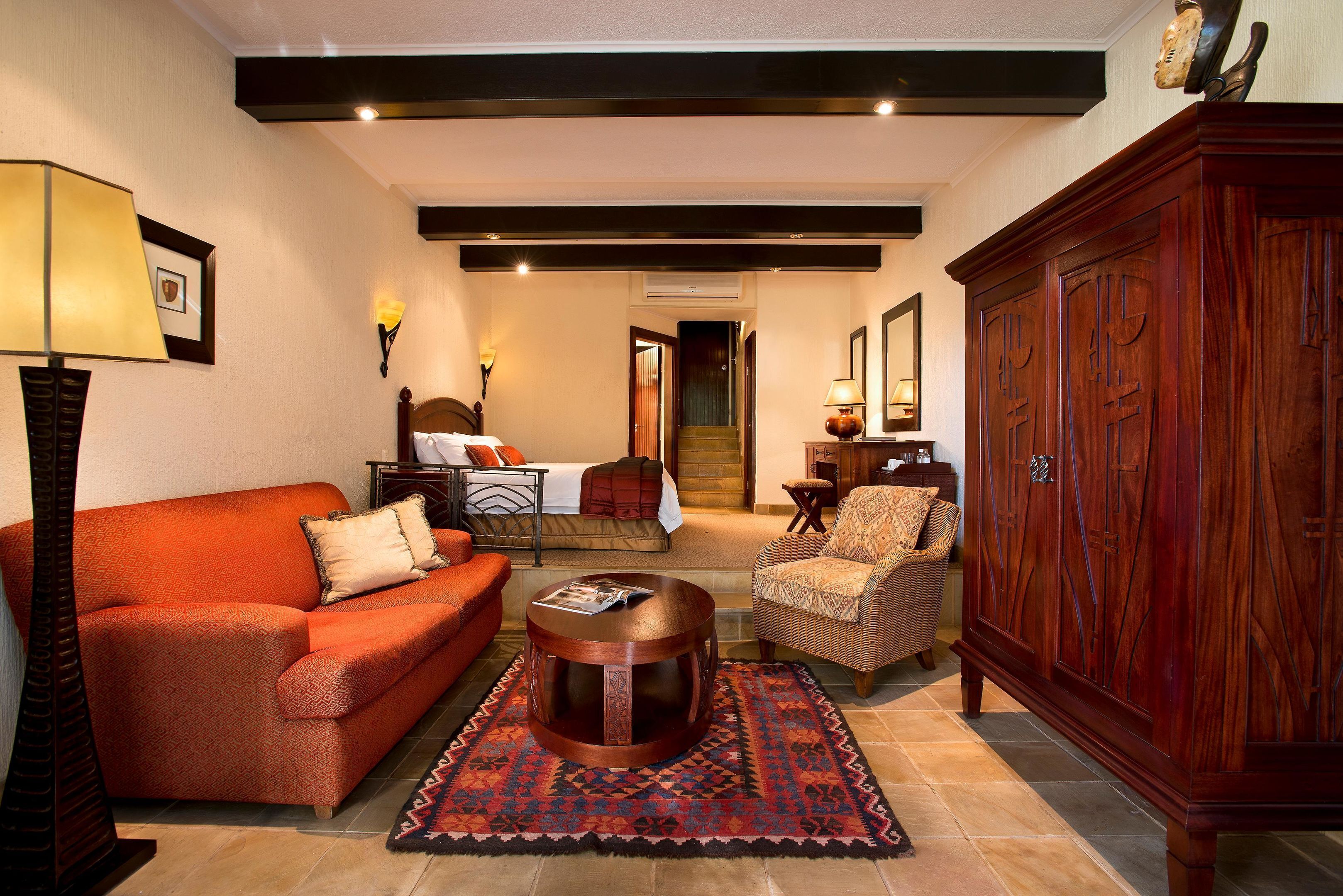Una sala de estar con sofá, sillón y un mueble de madera.