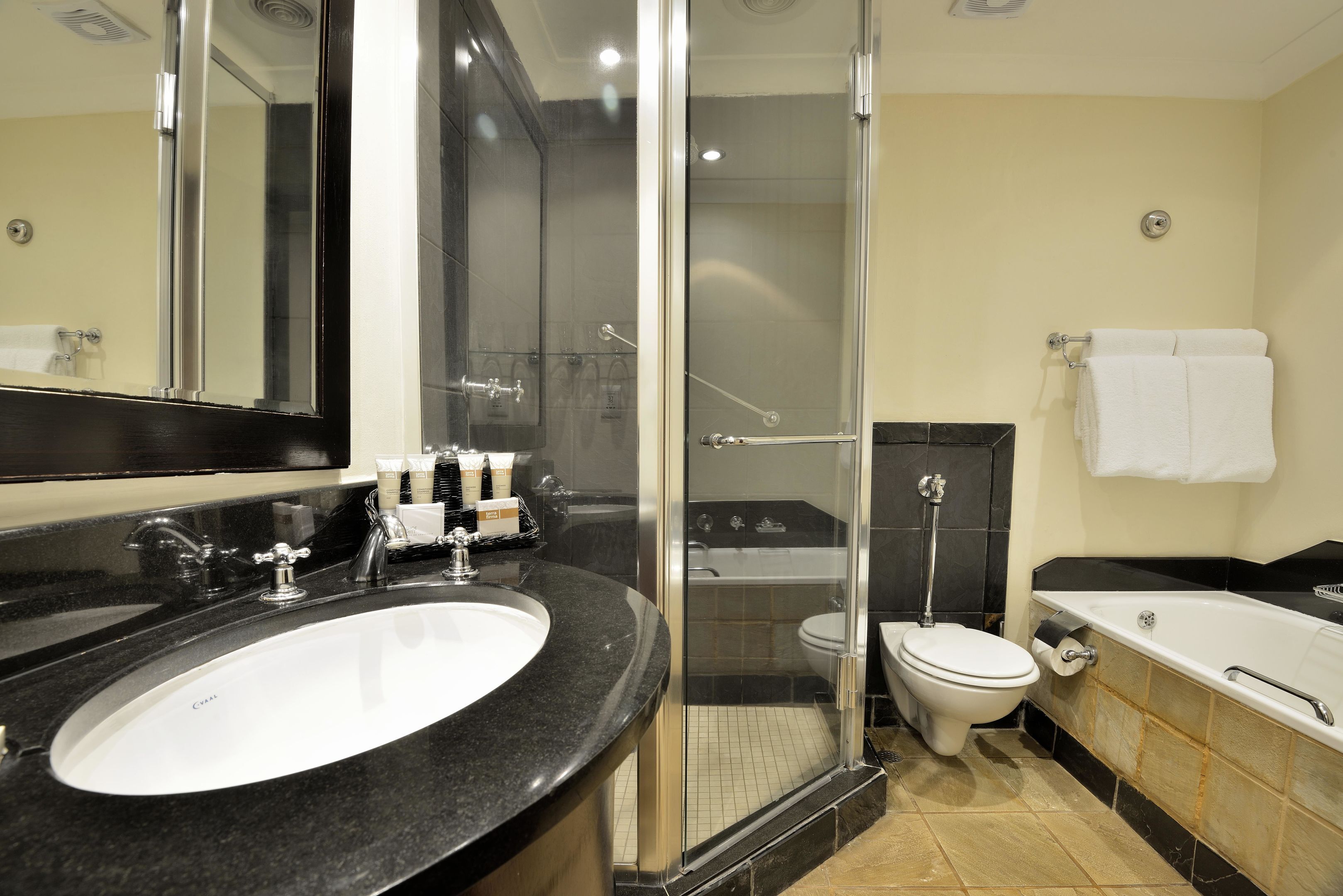 A modern bathroom with a large sink, toilet, and bathtub.