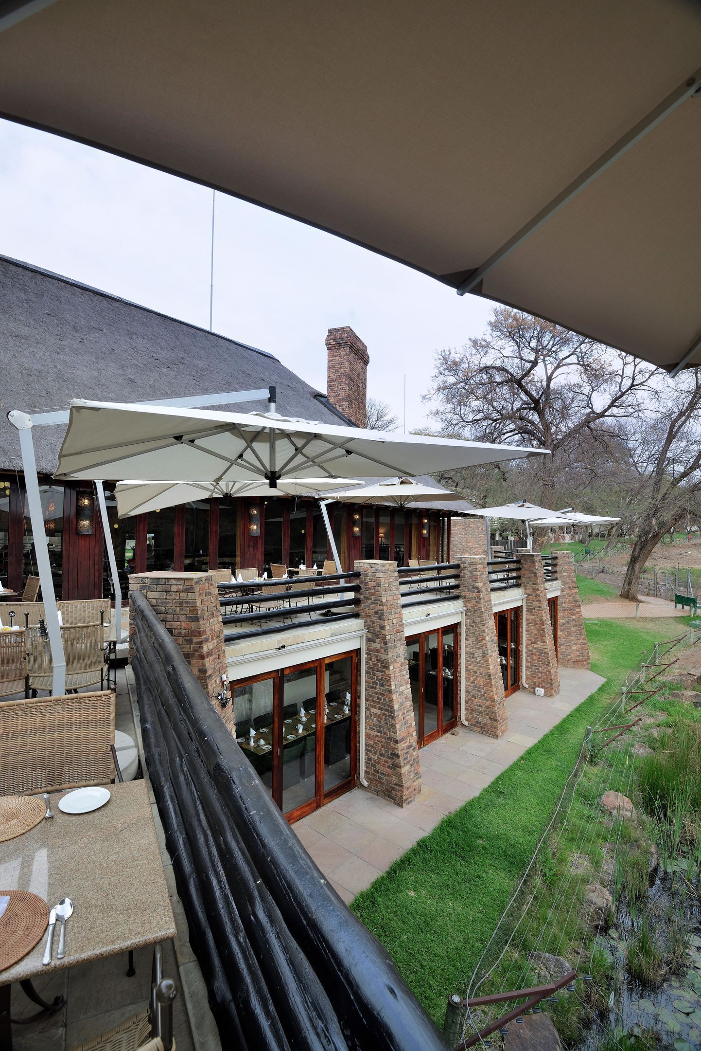 A restaurant with outdoor seating, brick walls, and a covered patio area.