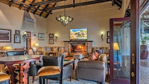 A cozy living room with a fireplace, comfortable seating, and a large TV.