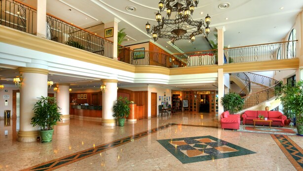 A spacious lobby with a marble floor, a central red sofa, and a staircase leading to an upper level. - Sunway Hotel Phnom Penh (Phnom Penh)
