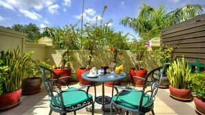 A patio with a round table, two chairs, and potted plants. - Sunway Hotel Phnom Penh (Phnom Penh)