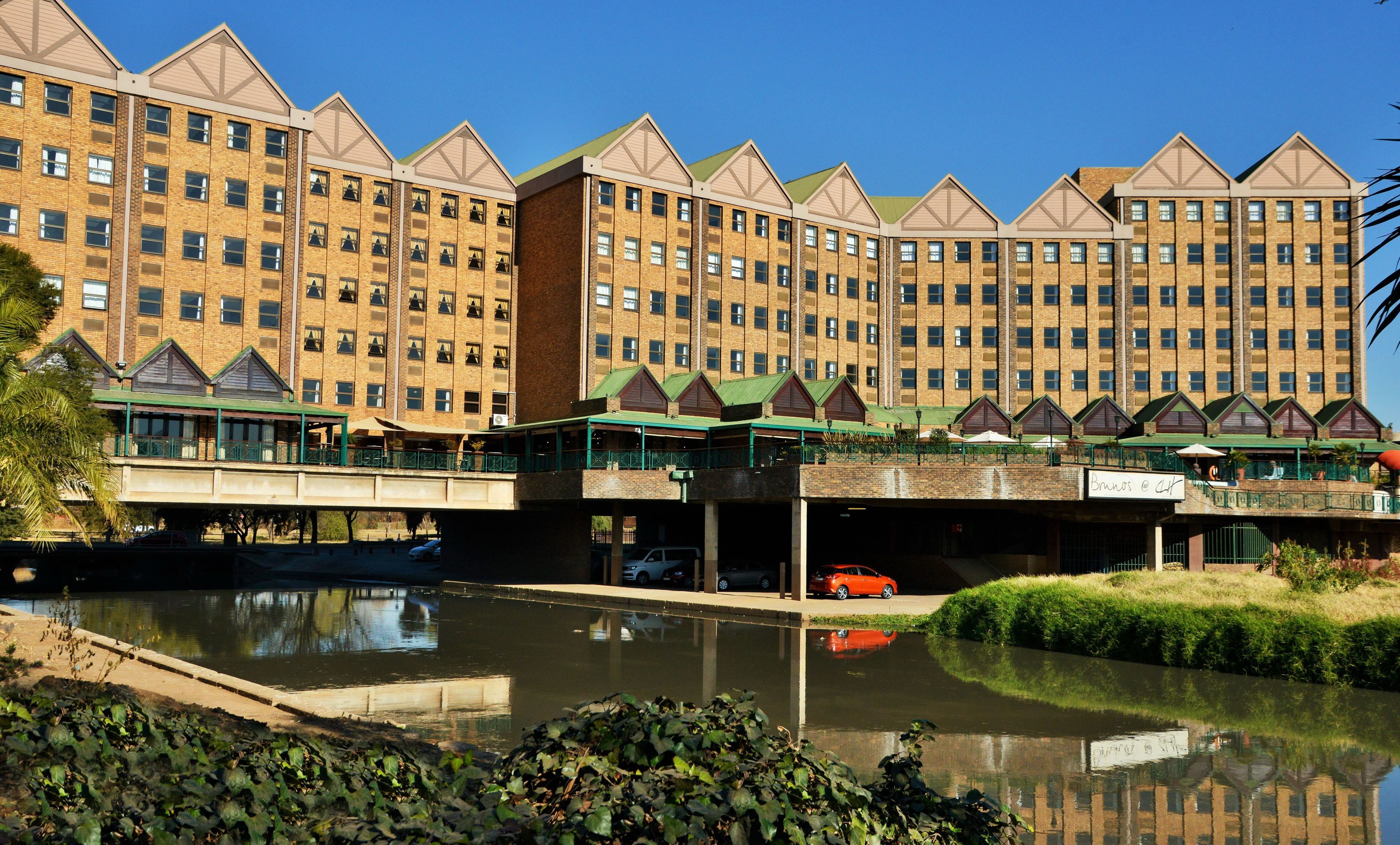 A multi-story hotel with a central courtyard and a canal.