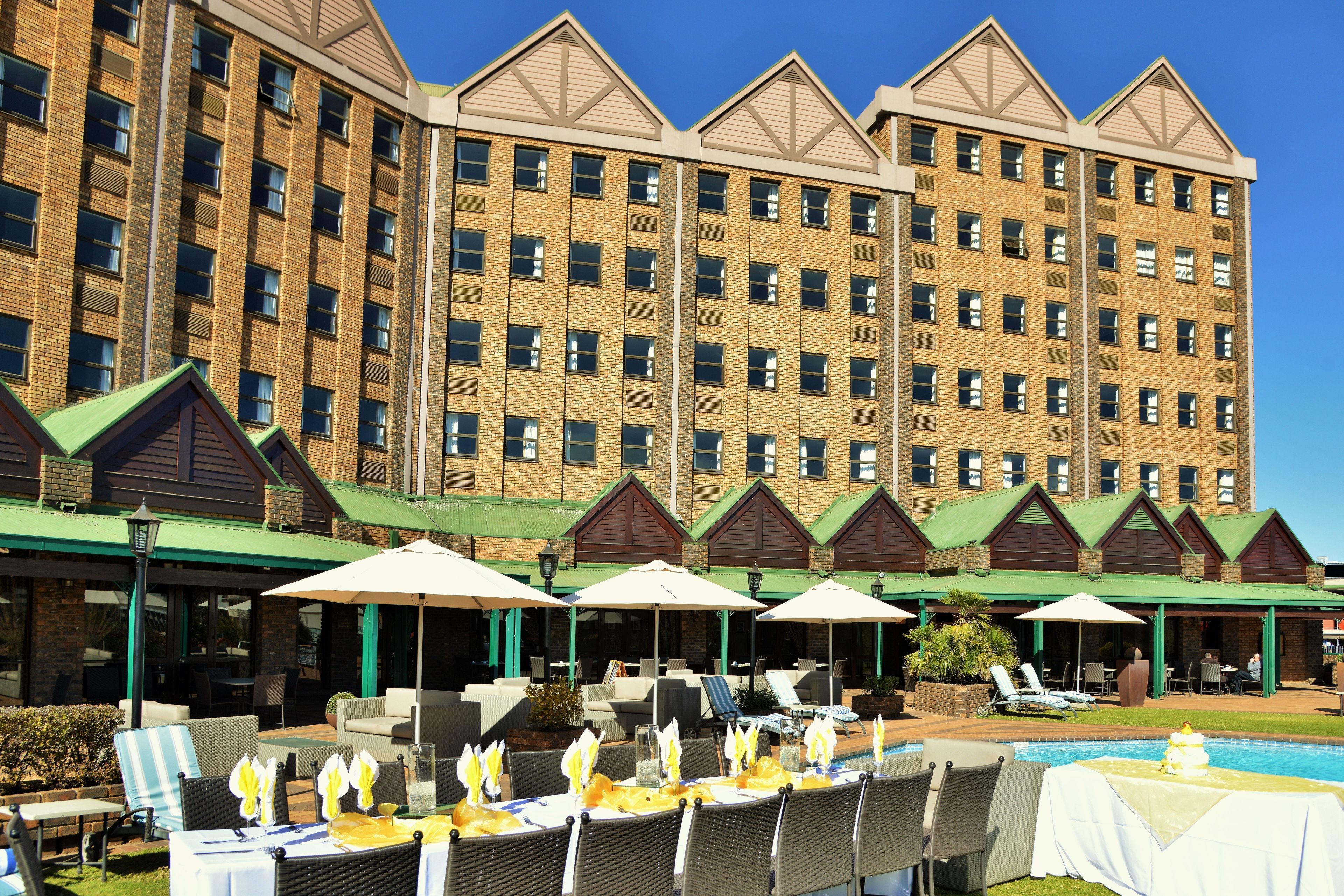 Een hotel met terras en zwembad.