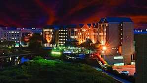 Un hotel con varias construcciones, un río y un puente.