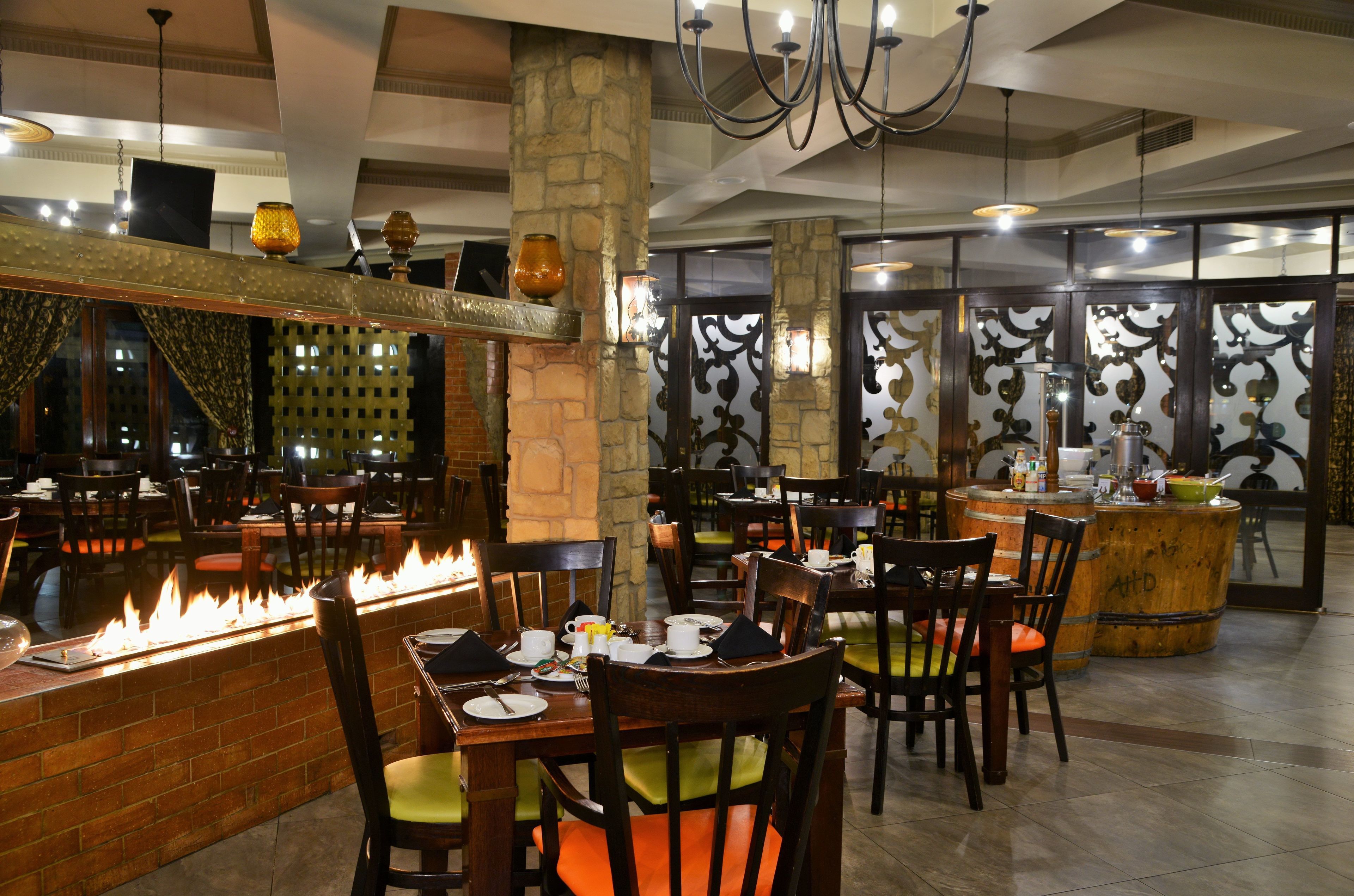 Un restaurante con chimenea de ladrillo, mesas y sillas de madera.