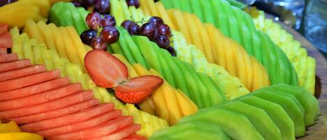 A fruit platter with various sliced fruits and grapes.