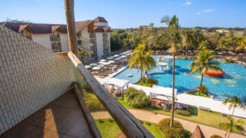 Un hotel con piscina, palmeras y vistas del paisaje circundante.