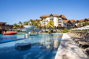 Una piscina techada, una piscina al aire libre, sombrillas