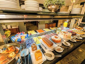 Un buffet garni de divers plats et agrémenté d’un grand vase décoratif.