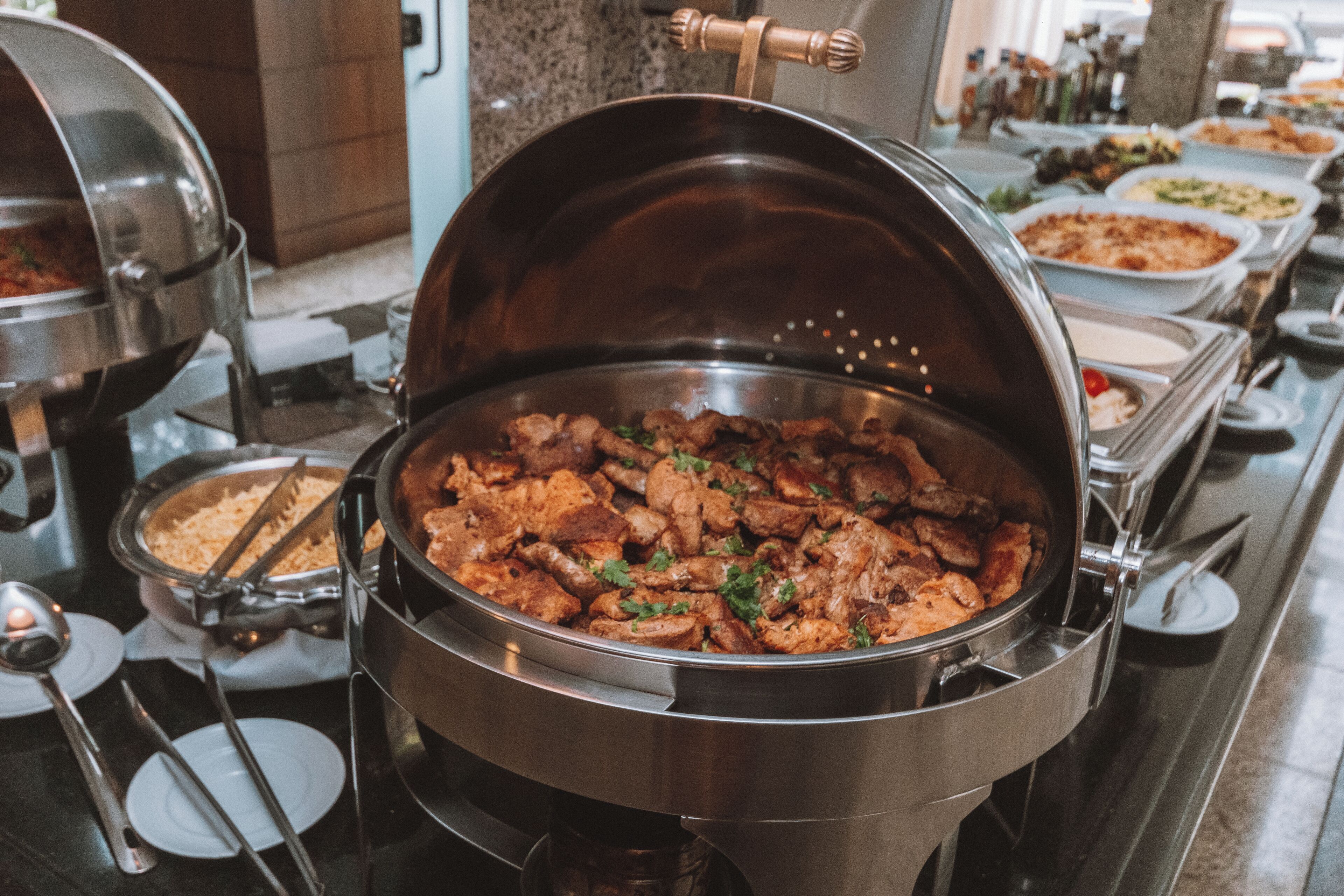 A buffet with various dishes, including a large pot of meat and several side dishes.