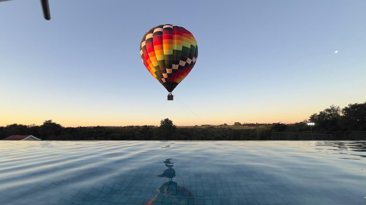 A hot air balloon over a body of water with a clear sky.