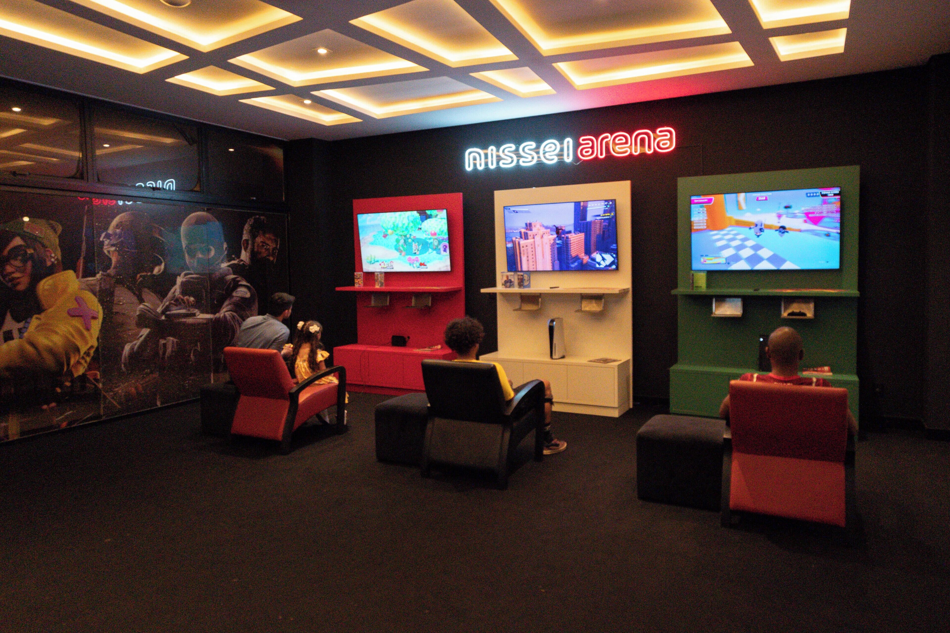 A gaming lounge with multiple screens and comfortable seating areas.