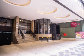 A hotel entrance with a staircase, a glass wall, and a sign for 'San Juan Hotéis'. - SJ Business - San Juan São Paulo (São Paulo)