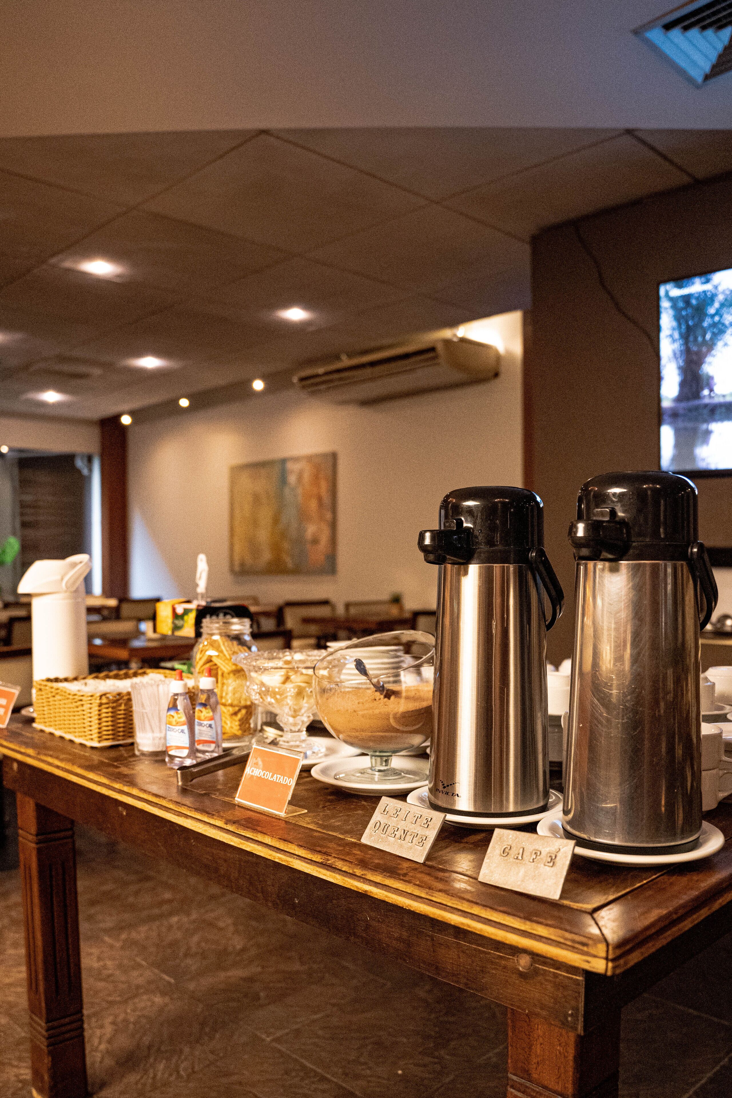 A buffet setup with hot beverages and labeled food items.