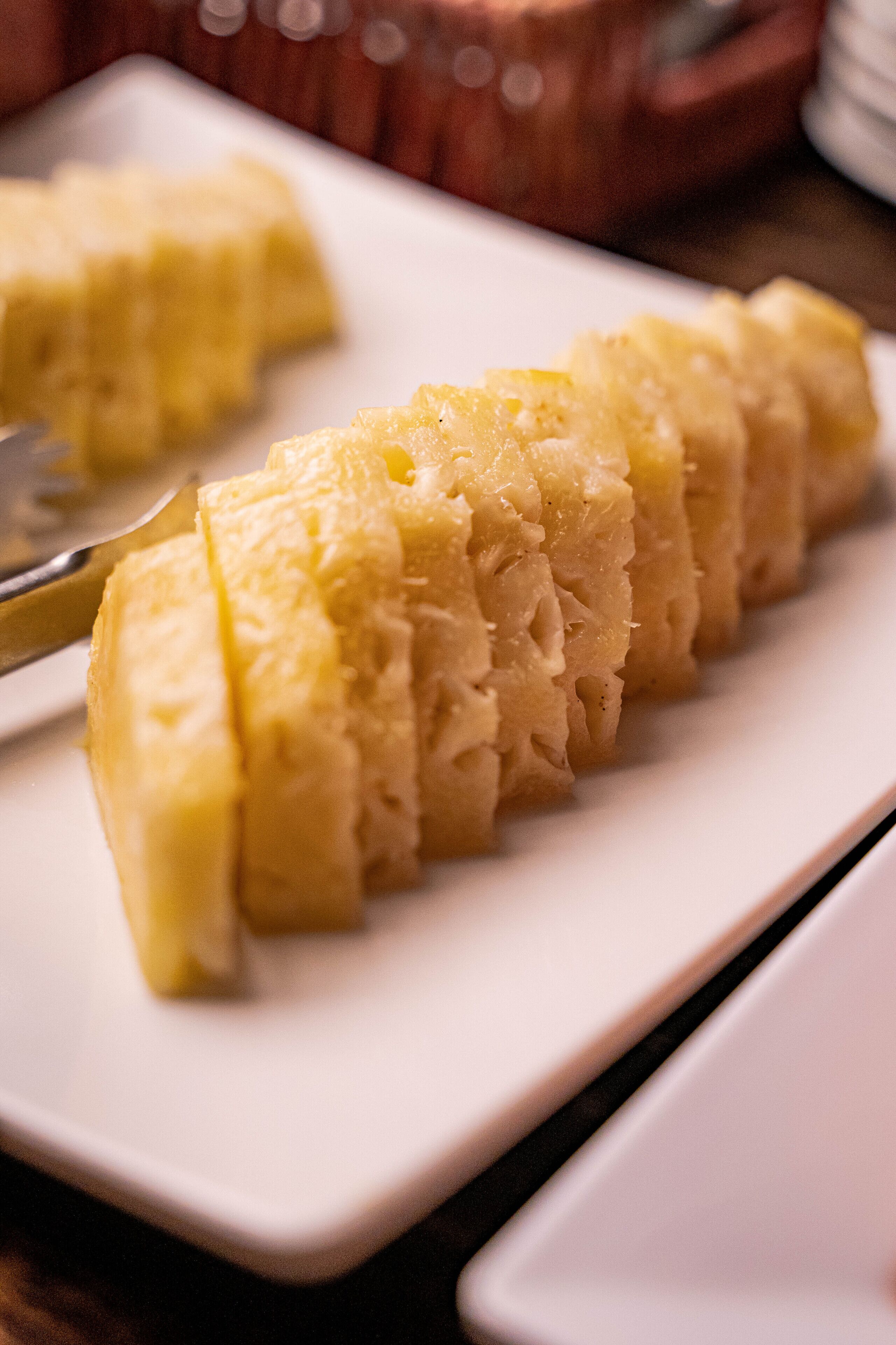 A white rectangular plate with a neatly arranged slice of yellow cake.
