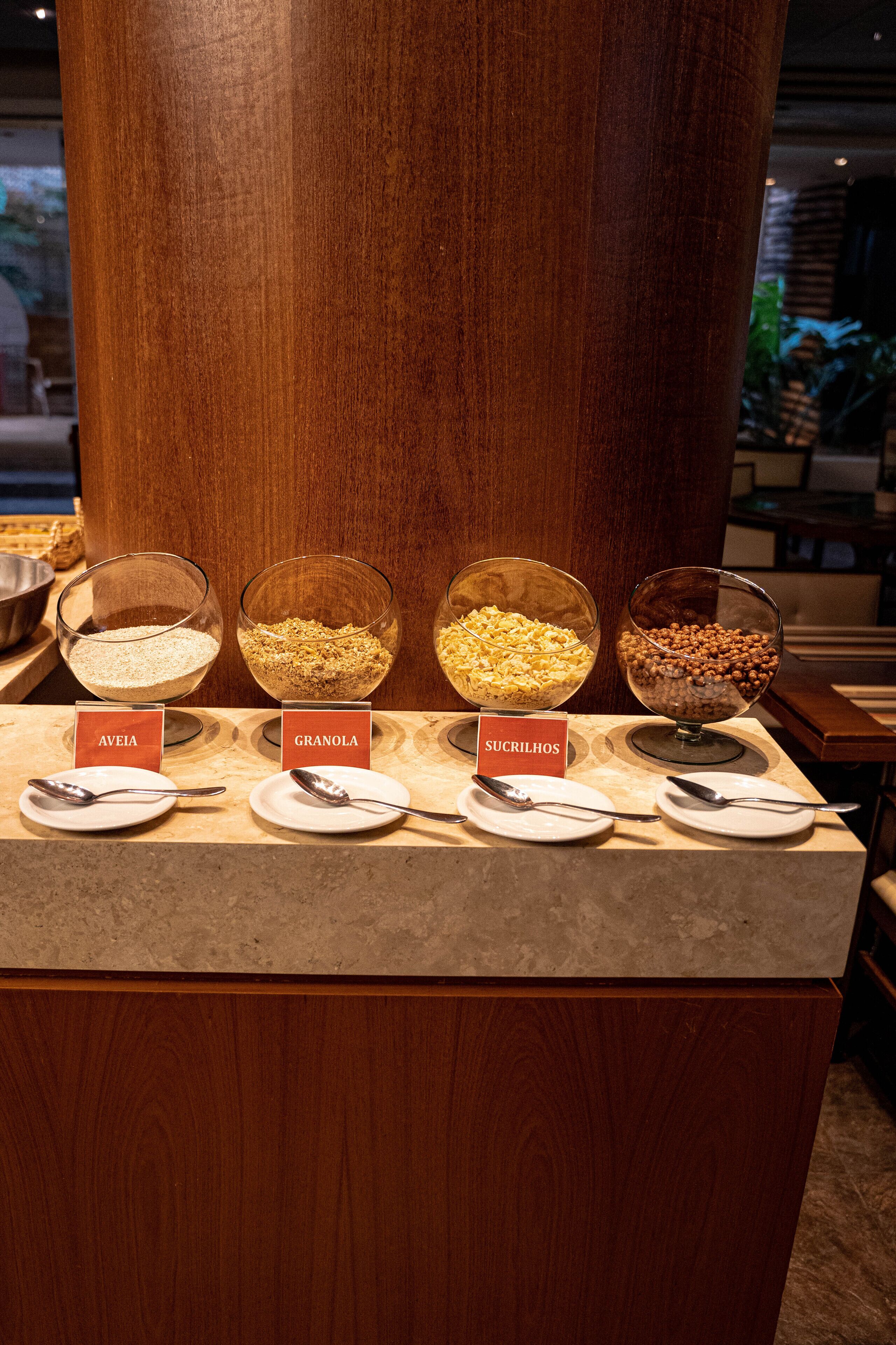 Mostrador de buffet con cuencos etiquetados de diversos alimentos.